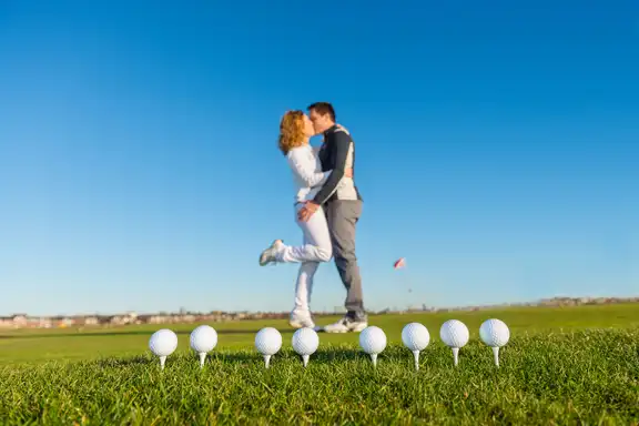 Hochzeitspaar vor Golfbällen
