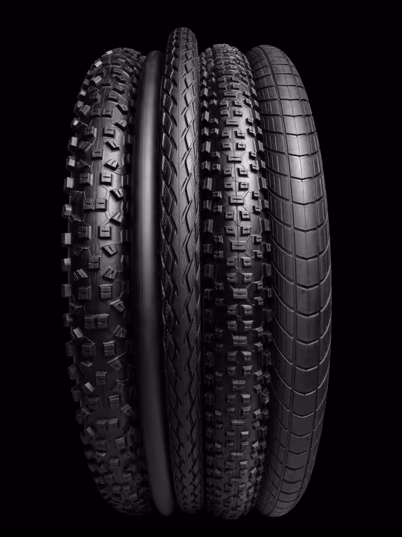 schwarze Fahrradschläuche mit unterschiedlichem Profil vor schwarzem Hintergrund